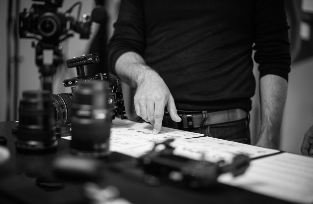 A man with photographic equipment looking at some notes