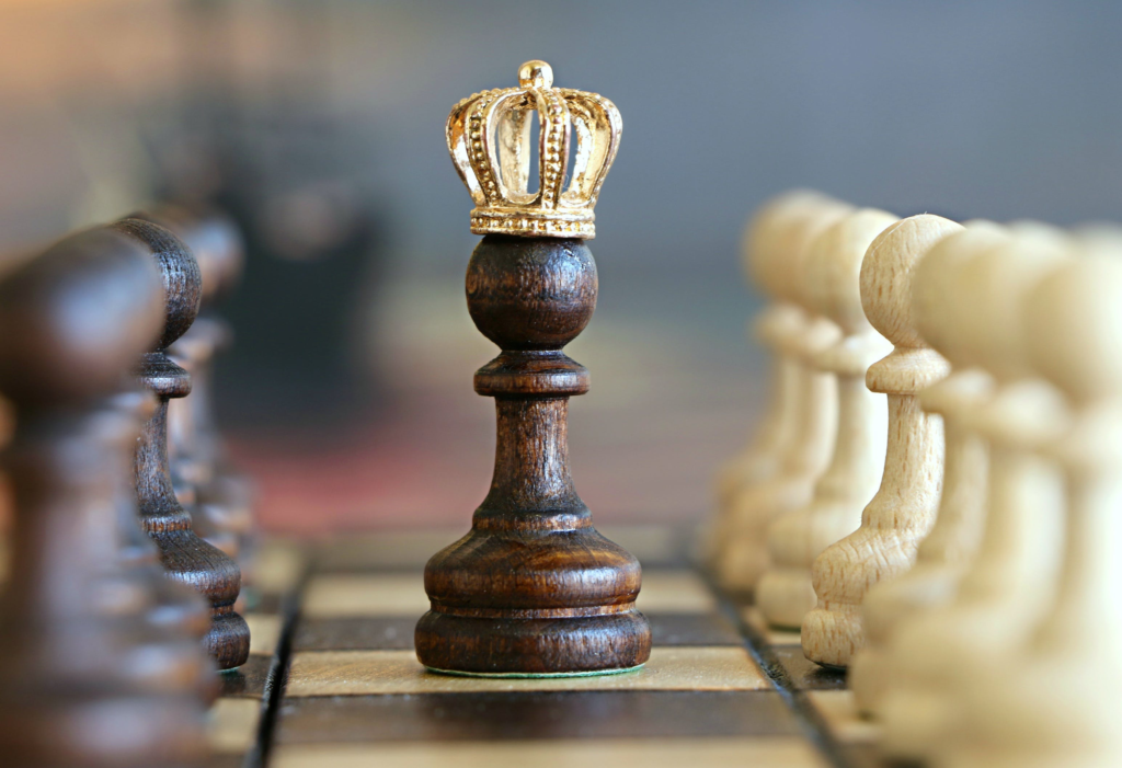 A chessboard with a pawn wearing a golden crown