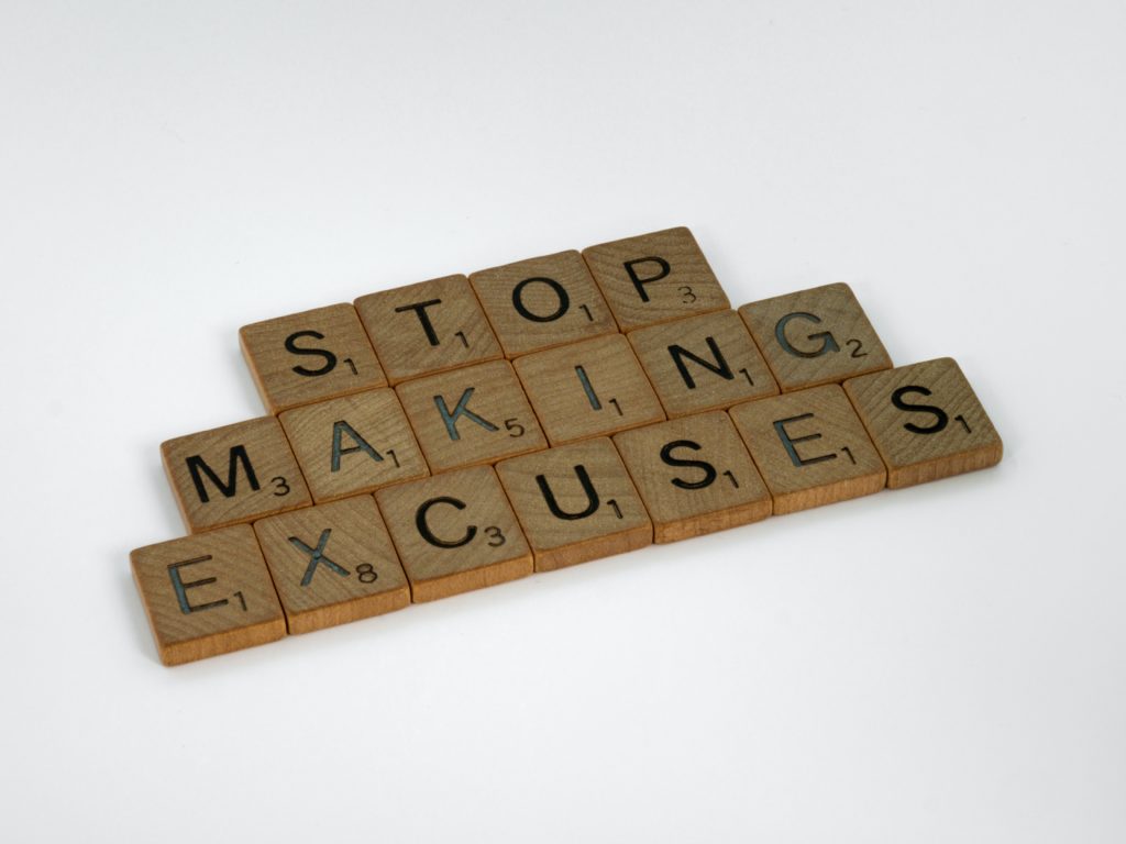Scrabble letter blocks arranged in the words: "Stop making excuses"