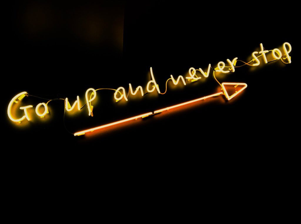 A sign with the words:" Go up and never stop"