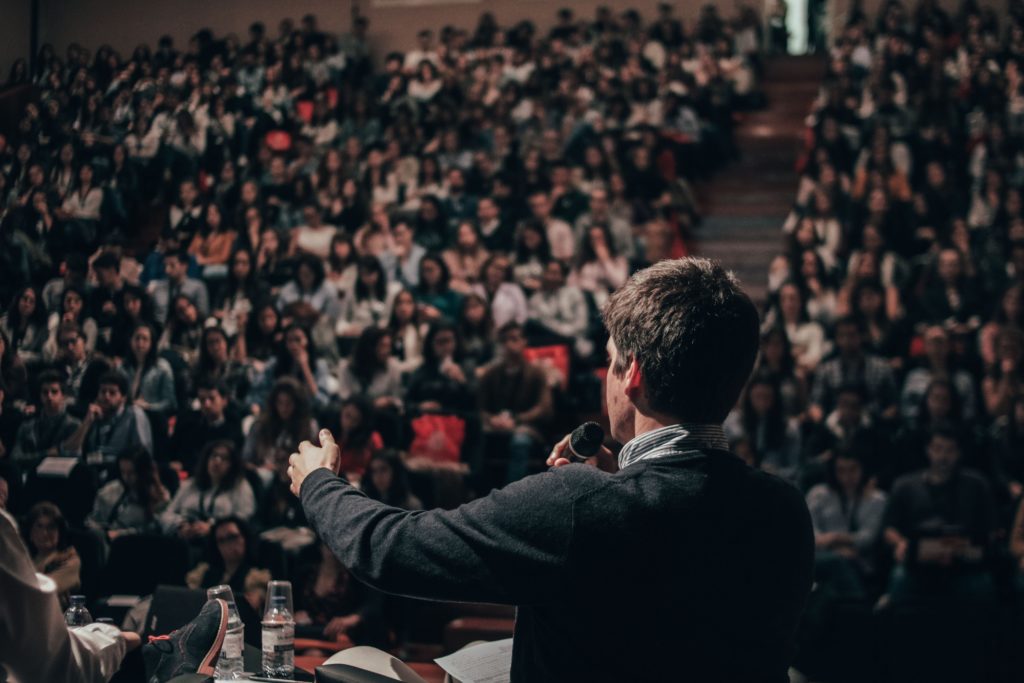 A male speaker standing in front of a big audience