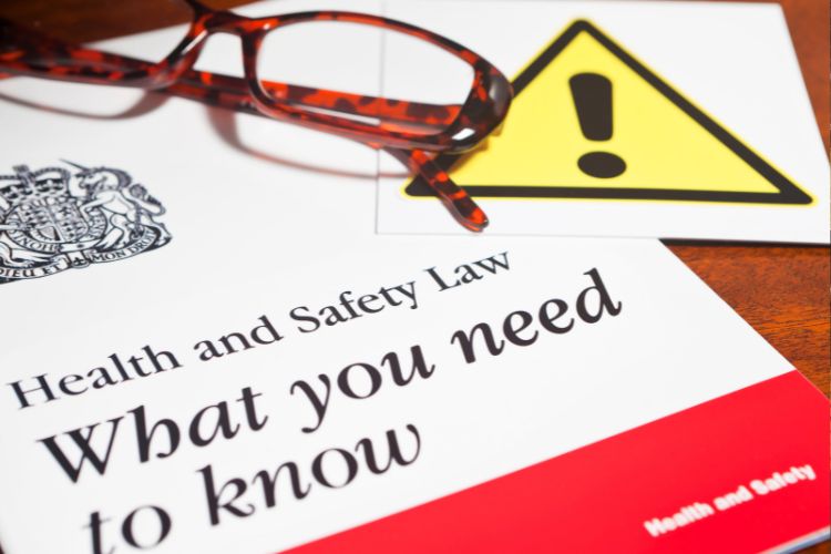 Health and Safety documents and a pair of spectacles.