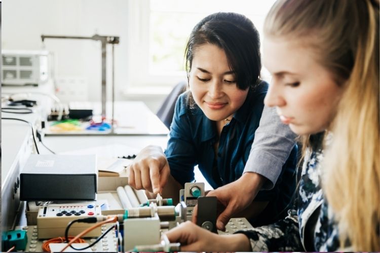 Two women in a lab working with electronics.