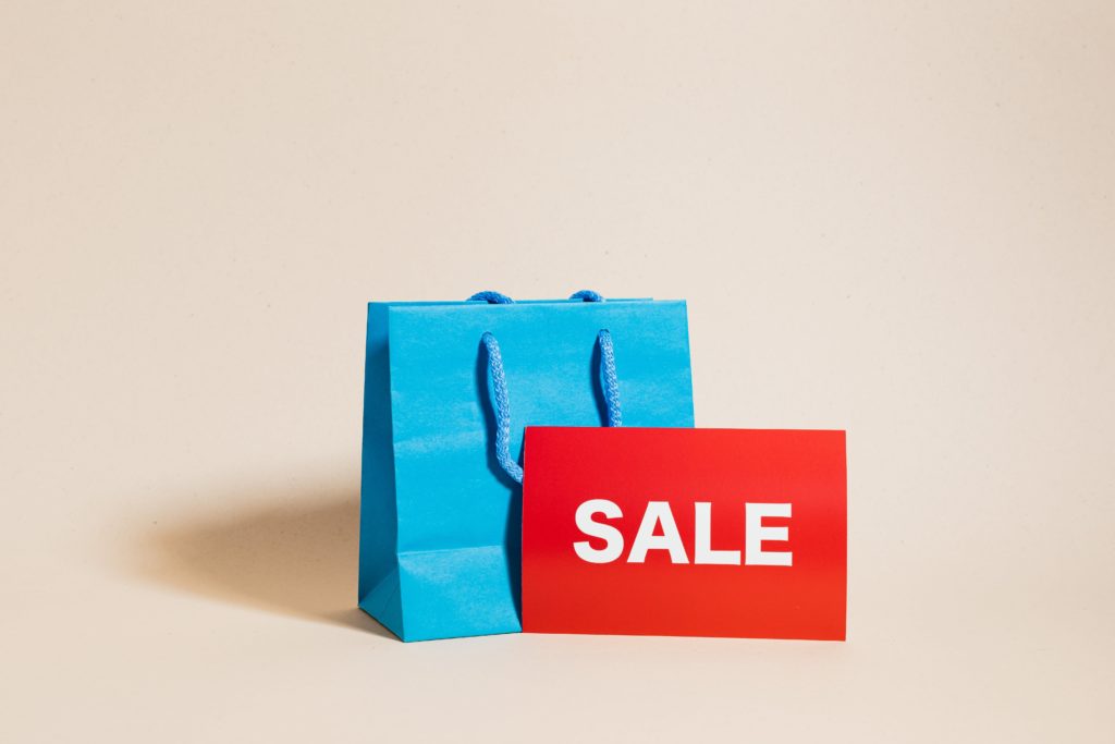 A gift bag with a red "SALE" sign