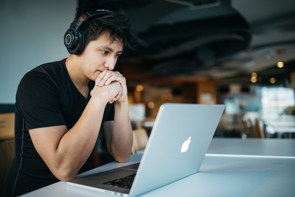 A man with headphones working on a laptop