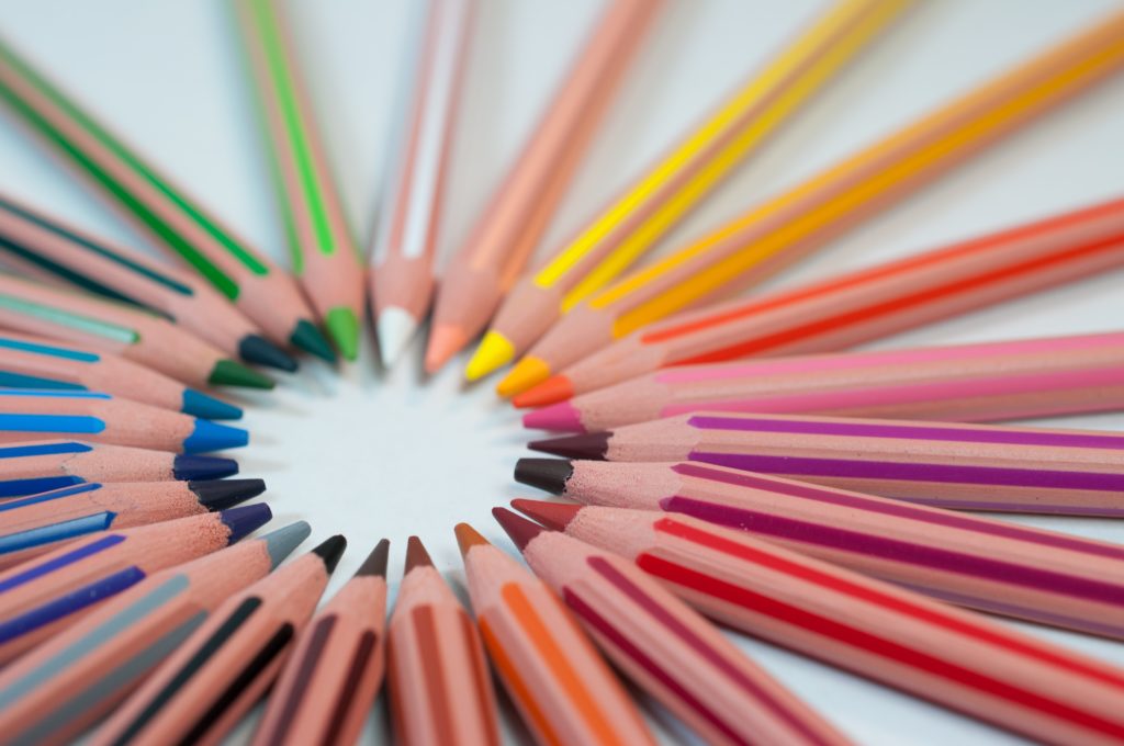 A set of colored pencils arranged in a circle, depicting collaboration from diverse people.