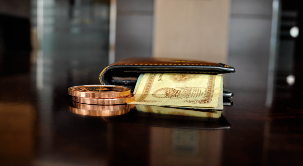A wallet with dollar bills and some coins.
