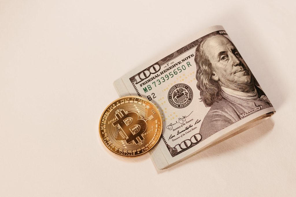 Dollar bills and a bitcoin.