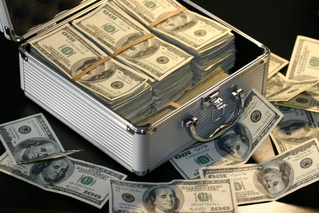 A silver case with stacks of dollar bills in it.