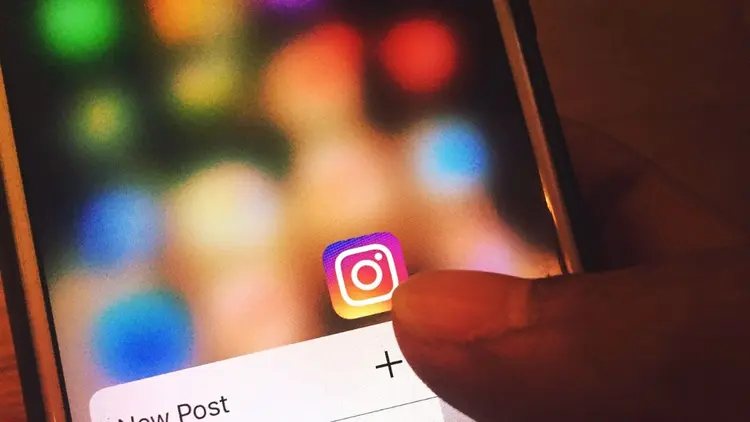A close up image of a cellphone screen with the Instagram App icon in focus.