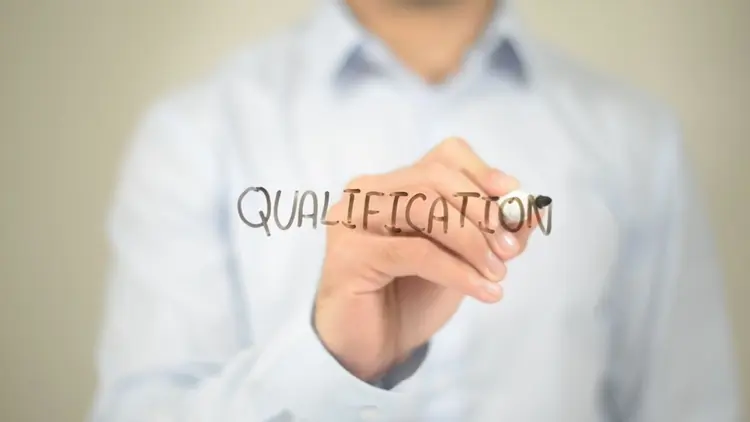 A man writing the word "qualification".