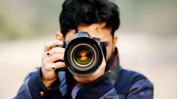 A close up of a photographer and his lens. 