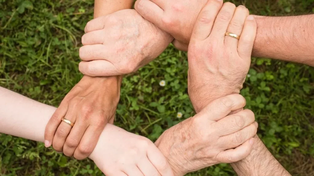 A group of people holding hands in a circle.