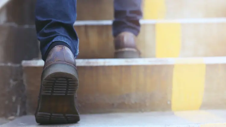 A close up of a man walking up some steps. 
