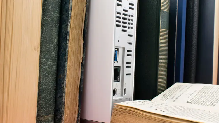 A book case with a computer CPU filed in between the books. 
