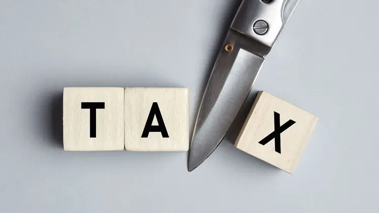 The word Tax with a pair of scissors, depicting tax cuts.
