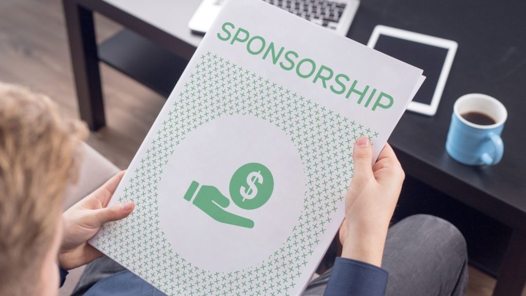 A man holding a folder with the word "sponsorship" on it. 