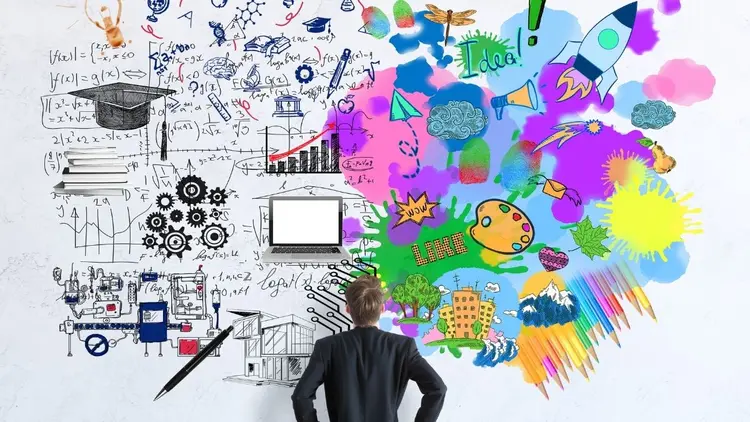 A man looking at wall covered in color, graphs and notes, depicting creativity. 