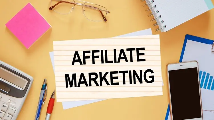 A desk with a calculator, spectacles, a cellphone and a notebook with the words: "Affiliate Marketing".