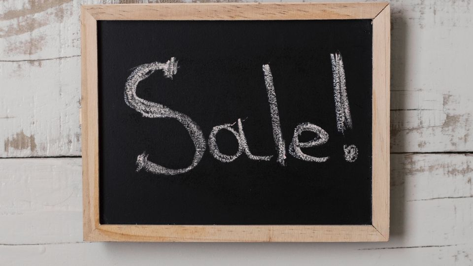 A chalkboard with the word : "Sale" written on it. 