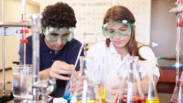 Two people doing experiments in a lab. 