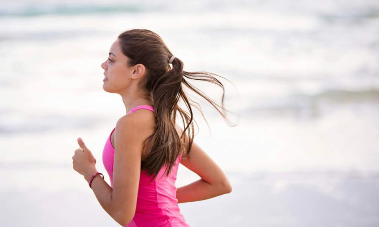 A young woman jogging on the beach.