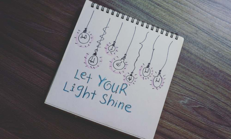 A notepad with the words "Let Your Light Shine" scribbled on it.