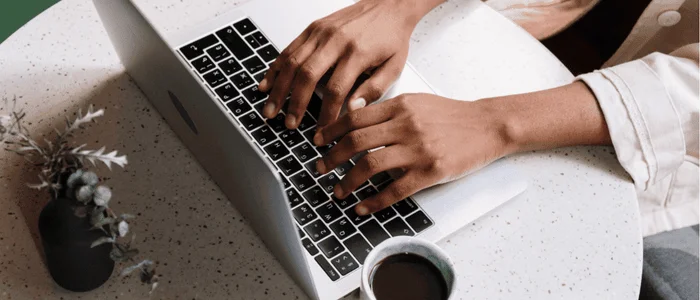 hands typing on laptop for brand community strategies