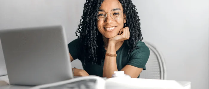 smiling woman working on community design project at a laptop